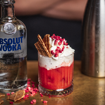 Cheesecake drink på et bord og en flaske Absolut Vodka