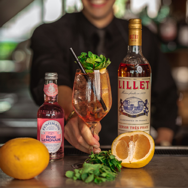 Rosé Rosé Spritz drink i et vinglas med en flaske Lillet Rosé og Rosé Lemonade.