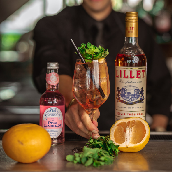 Rosé Rosé Spritz drink i et vinglas med en flaske Lillet Rosé og Rosé Lemonade.