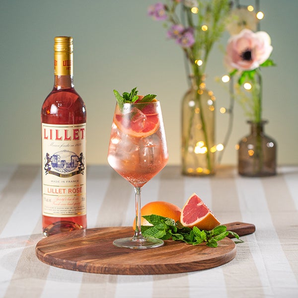 Rosé Rosé Spritz på et bord med en flaske Malfy Gin Rosa og Lillet Rosé