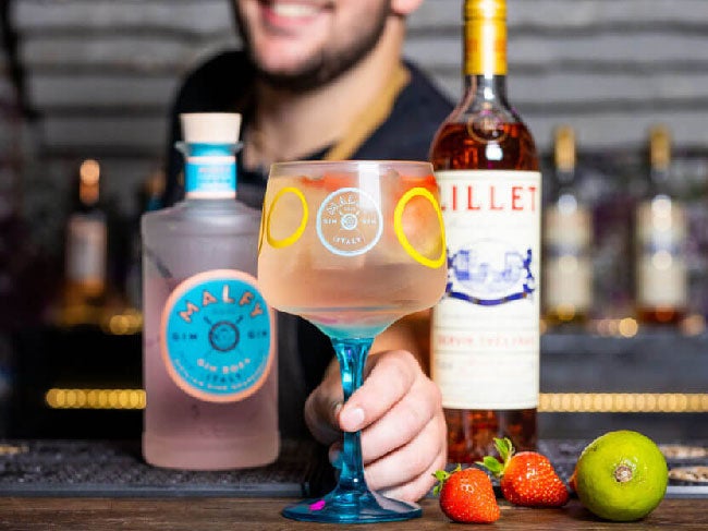 Rosa Rosé drink på et bord med en flaske Malfy Gin Rosa og Lillet Rosé
