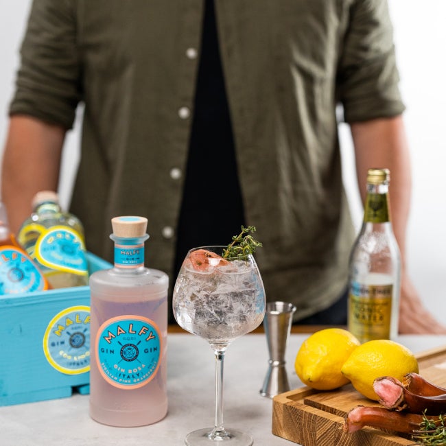 Ginbisse's Perfect Serve a en Gin & Tonic drink med rabarber. En flaske tonic og en flaske Malfy Gin Rosa.