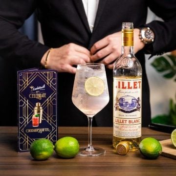 Light N Breezy Cocktail på et bord med en flaske Lillet Blanc og lime