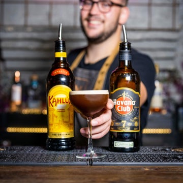 En PVs Espresso Martini i et cocktailglas med en flaske Kahlúa og Havana Club 7