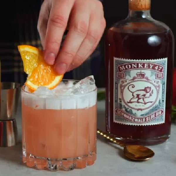 En Sloe Gin Sour Cocktail og en flaske Monkey 47 Sloe Gin