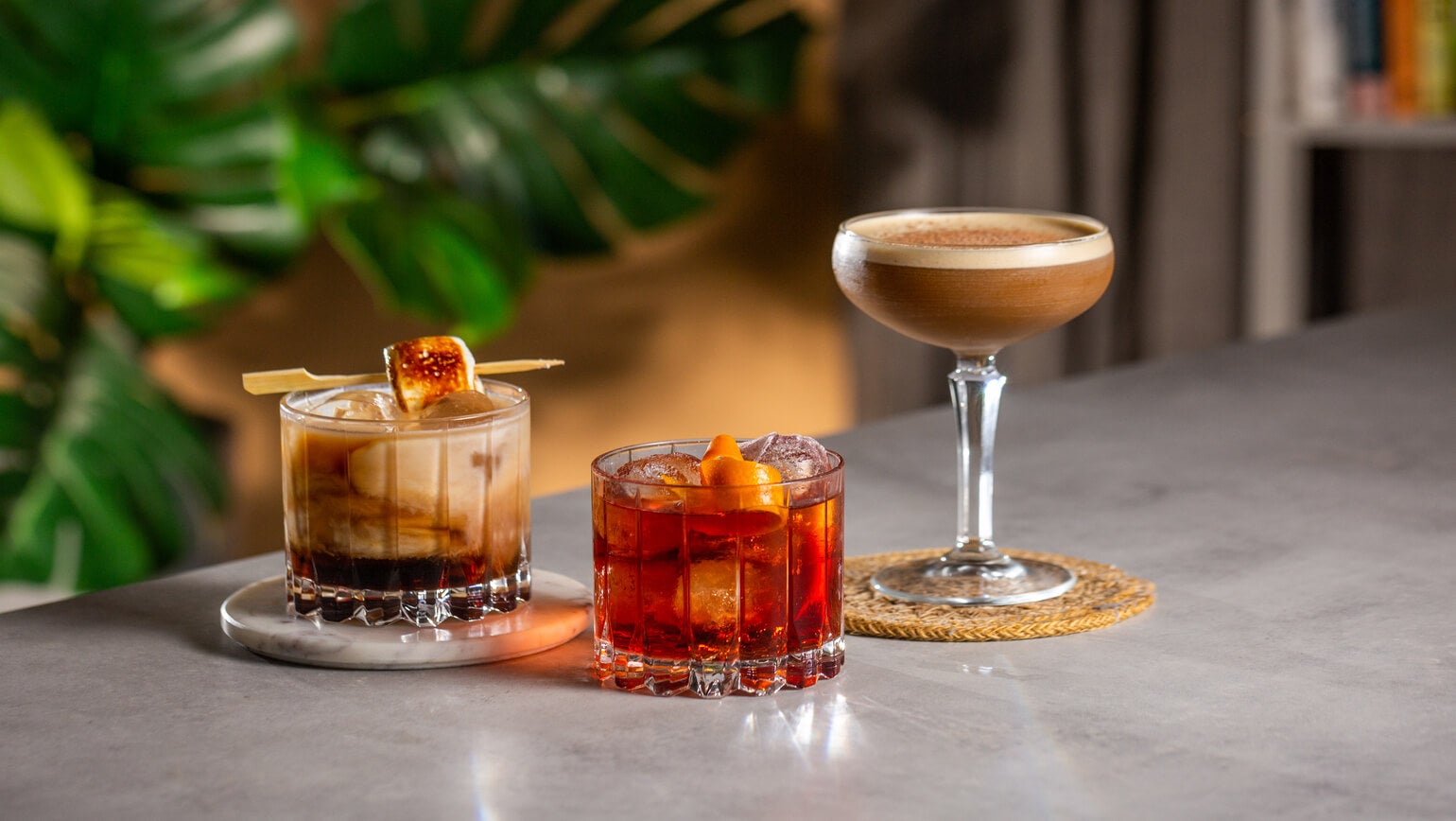 3 cocktails med Kahlúa på et bord. Fra venstre en Flat White Russian, Coffee Negroni og Latte Martini.