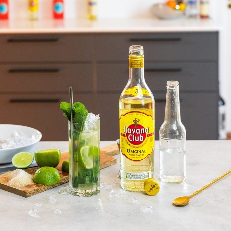 En Havana Club 3 års flaske og en Mojito drink på et køkkenbord
