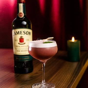 Julesour cocktail på et bord med en flaske Jameson Irish Whiskey