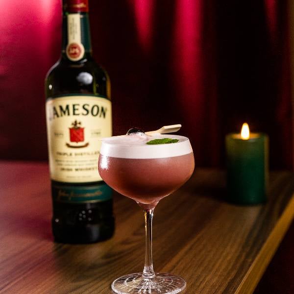 Julesour cocktail på et bord med en flaske Jameson Irish Whiskey