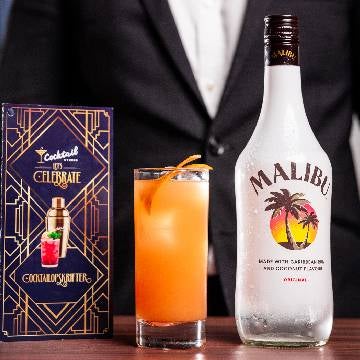 Malibu Splash cocktail på et bord med en flaske malibu