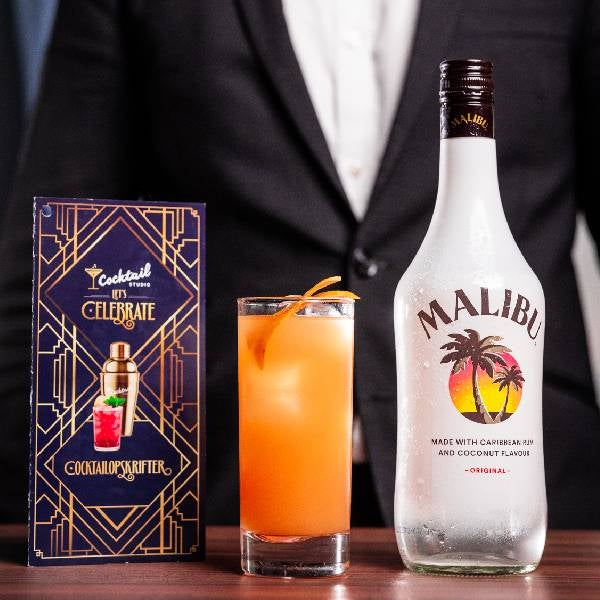 Malibu Splash cocktail på et bord med en flaske malibu