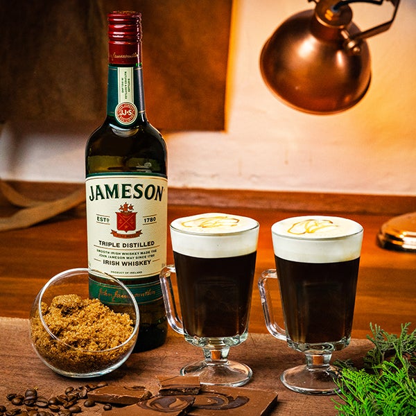 2 Irish Coffee Salted Caramel drinks på et spækbræt. En flaske Jameson Irish Whiskey.