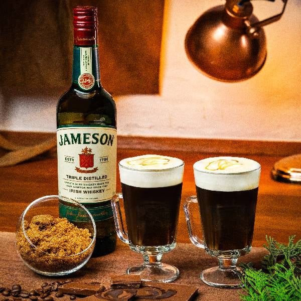 2 Irish Coffee Salted Caramel drinks på et spækbræt. En flaske Jameson Irish Whiskey.