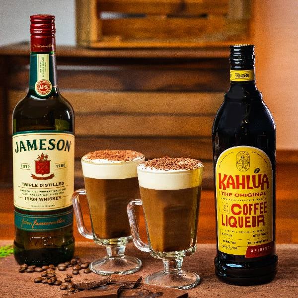 2 Irish Coffee med Kahlúa drinks på et spækbræt. En flaske Jameson Irish Whiskey og en flaske Kahlúa.