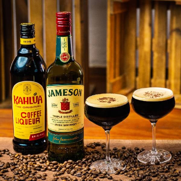 2 Irish Espresso Martini på et spækbræt. En flaske Jameson Irish Whiskey og en flaske Kahlúa.