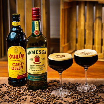 2 Irish Espresso Martini cocktails på et spækbræt. En flaske Kahlúa og en flaske Jameson Irish Whiskey.