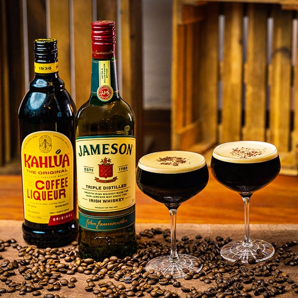 2 Irish Espresso Martini cocktails på et spækbræt. En flaske Kahlúa og en flaske Jameson Irish Whiskey.