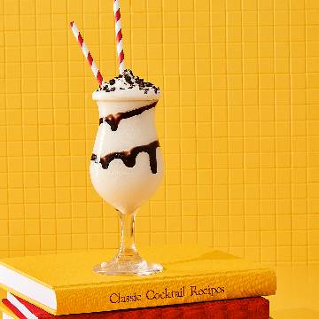 Kahlúa Mudslide cocktail placeret på en stak bøger om cocktails.