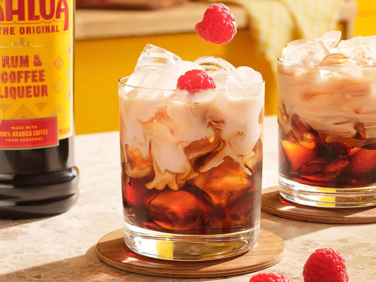 2 Frozen White Russian cocktails på et bord med en flaske Kahlúa.