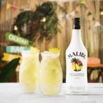 Malibu Pina Colada cocktail på et bord med en flaske Malibu