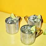 3 Moscow Mule drinks på et gult bord.