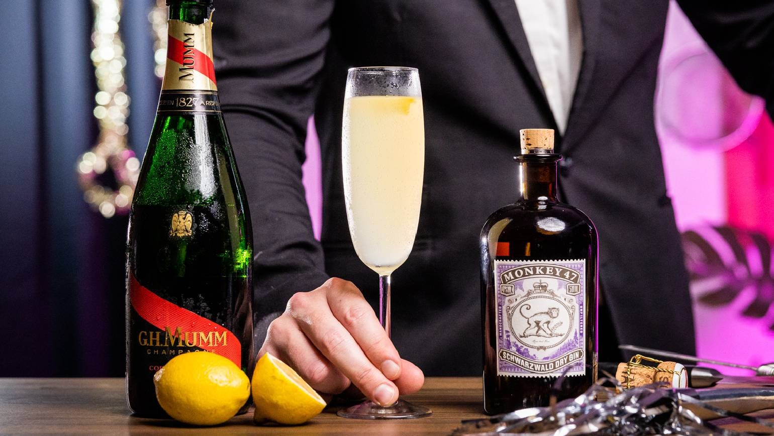 French 75 nytårscocktail på et bord med en flaske Mumm champagne
