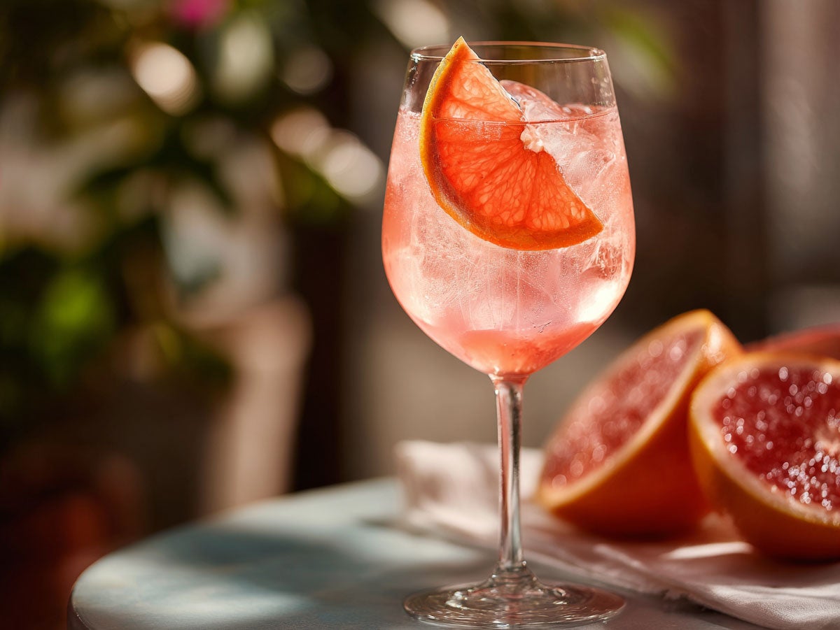 A bright pink spritzer drink placed atop a marbletop table. Created by AI. Edited by Pernod Ricard Sweden