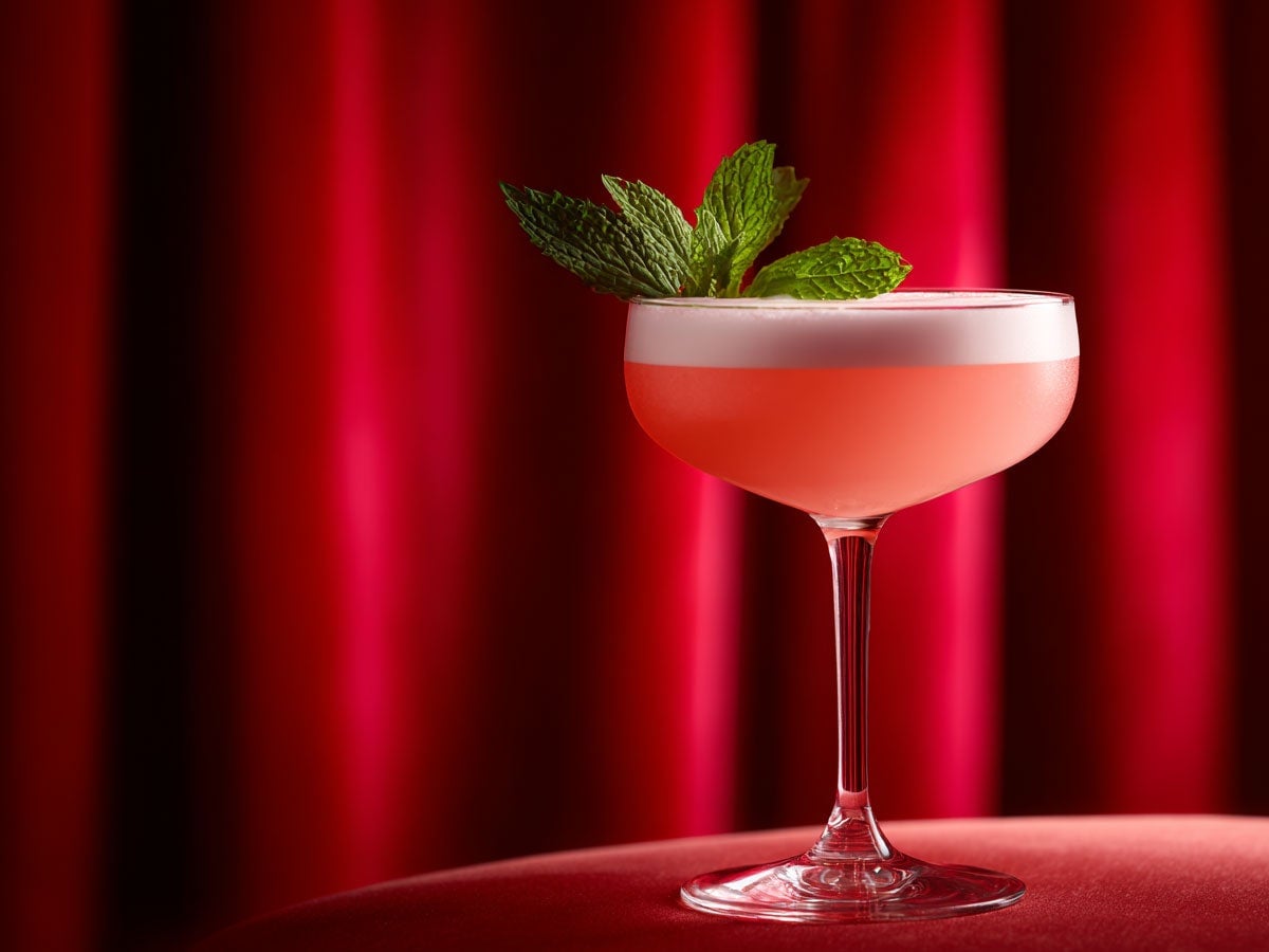 A pink drink, served in a coupe glass with foam on top, garnished with mint leaves. Created by AI. Edited by Pernod Ricard Sweden