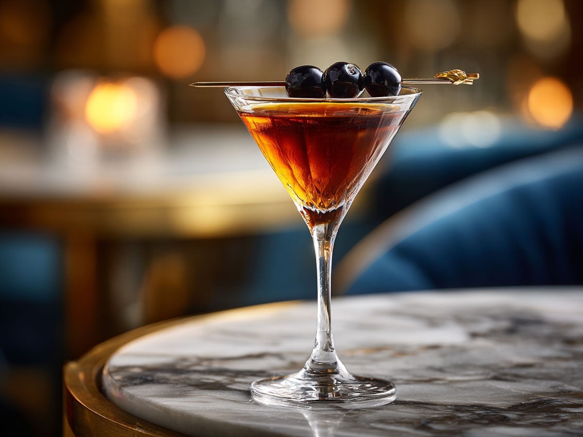 A classic Manhattan drink, garnished with olives served atop a marble table. Created by AI. Edited by Pernod Ricard Sweden